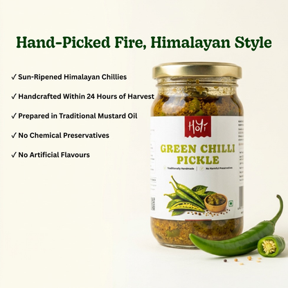 A jar of Hsyf Hand-Picked Fire, Himalayan Style Green Chilli Pickle displayed on a clean off-white background with descriptive text and fresh chili peppers. The product features a gold metal lid, a white label with green and red text, and a clear glass body showing the preserved green chilies and mustard oil inside.